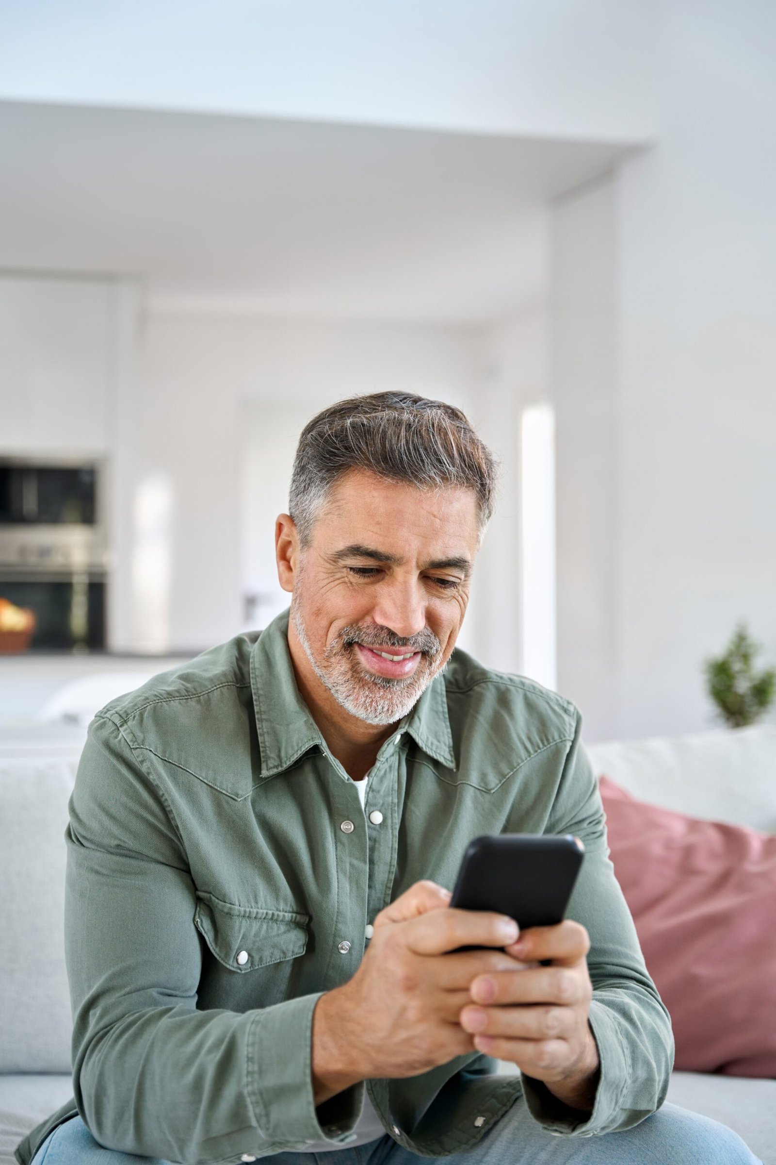 vertical,shot,of,middle,aged,man,using,smartphone,relaxing,on
